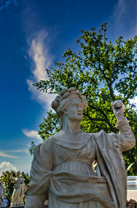 Low angle view of statue against trees and sky