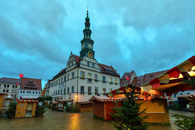 Buildings in city against cloudy sky