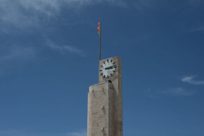 Low angle view of clock tower against blue sky