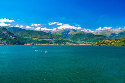 Scenic view of sea and mountains against blue sky