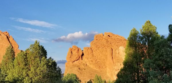 Panoramic view of trees and mountains against blue sky