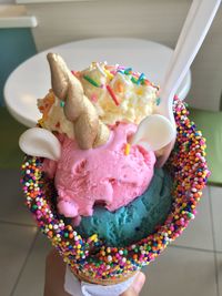 Cropped hand holding unicorn ice cream