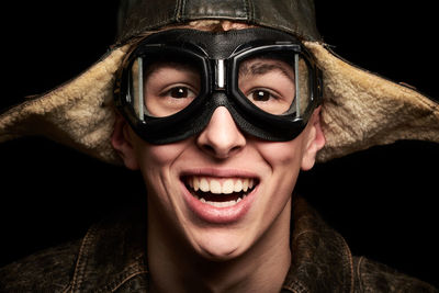 Portrait of smiling boy wearing eyewear against black background