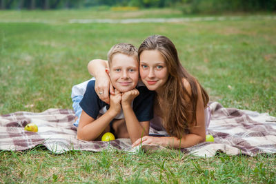 Portrait of smiling young woman lying on grass