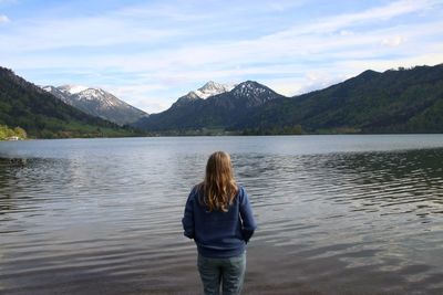 Rear view of woman looking at lake and mountains