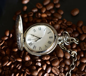 Close-up of pocket watch on roasted coffee beans