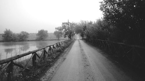 Narrow pathway along calm lake