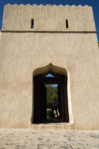 Rear view of woman against historic building