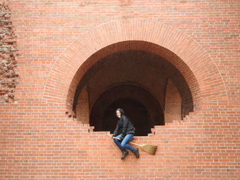 Man standing against brick wall