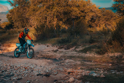 Man riding bicycle on field during autumn