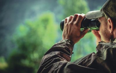 Rear view of man holding camera