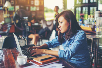 Woman sitting on table at cafe