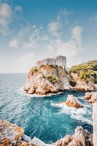 Rock formations by sea against sky