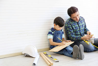 Father and son sitting in toy on floor