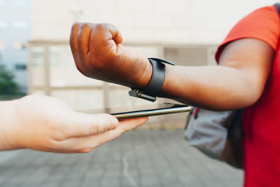 Customer using tap to pay method with smart phone and smart watch