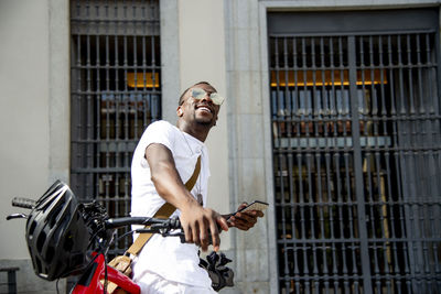 Young man on his bike using his smartphone