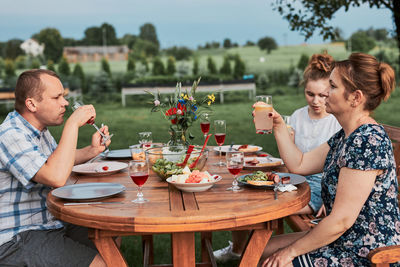 Family having food sitting outdoors