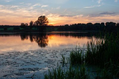 Scenic view of lake against sky at sunset