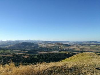 Scenic view of field against clear blue sky