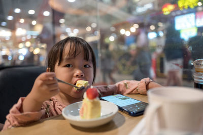 Portrait of boy eating ice cream in restaurant