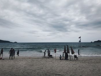 People on beach against sky