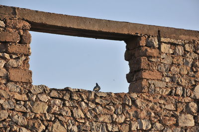 Low angle view of old wall against clear sky