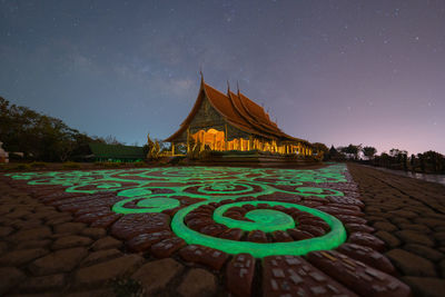 Illuminated building against sky at night