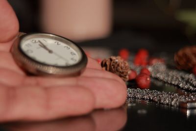 Close-up of hand holding clock