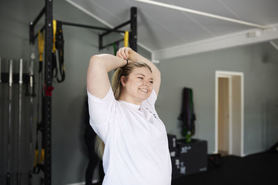 Blond woman stretching in gym