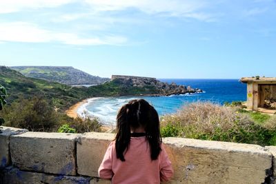 Rear view of woman looking at sea against sky