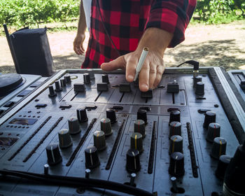 Close-up of hand holding sound console 