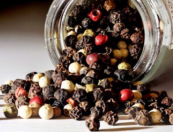 Close-up of dried berries spilling from jar on table