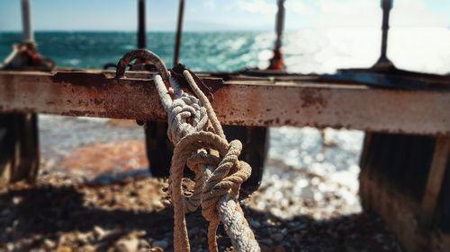Close-up of rope tied on metal at beach