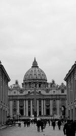 People in front of building against sky