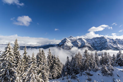 Scenic view of snowcapped mountains against blue sky