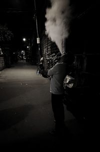 Woman standing on road at night