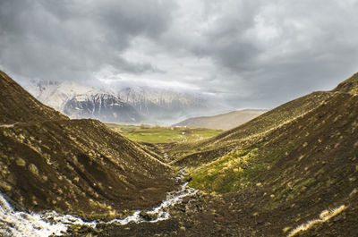 Scenic view of valley and mountains against sky