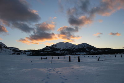 Scenic view of frozen mountains against sky during winter