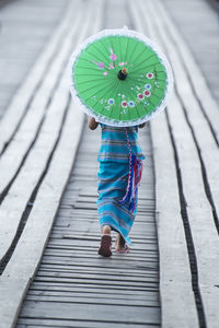 Rear view of a woman walking with umbrella