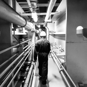 Rear view of man walking in industry