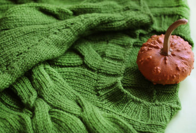 High angle view of pumpkin by sweater on table