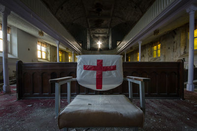 Cross sign on chair in abandoned church