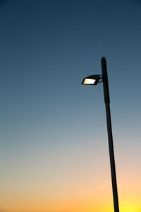 Low angle view of illuminated street light against clear sky