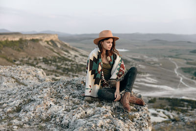 Young woman sitting on rock