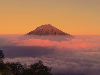 Scenic view of mountain against cloudy sky during sunset