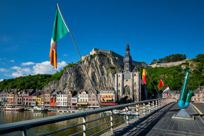 Low angle view of flag on building by mountain against sky