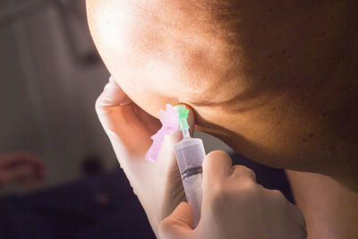 Close-up of doctor injecting patient on knee