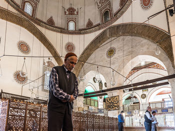 Low angle view of man standing against railing