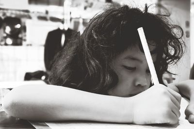 Close-up of girl writing on paper at table