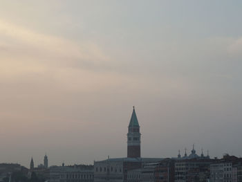 Buildings in city against sky during sunset